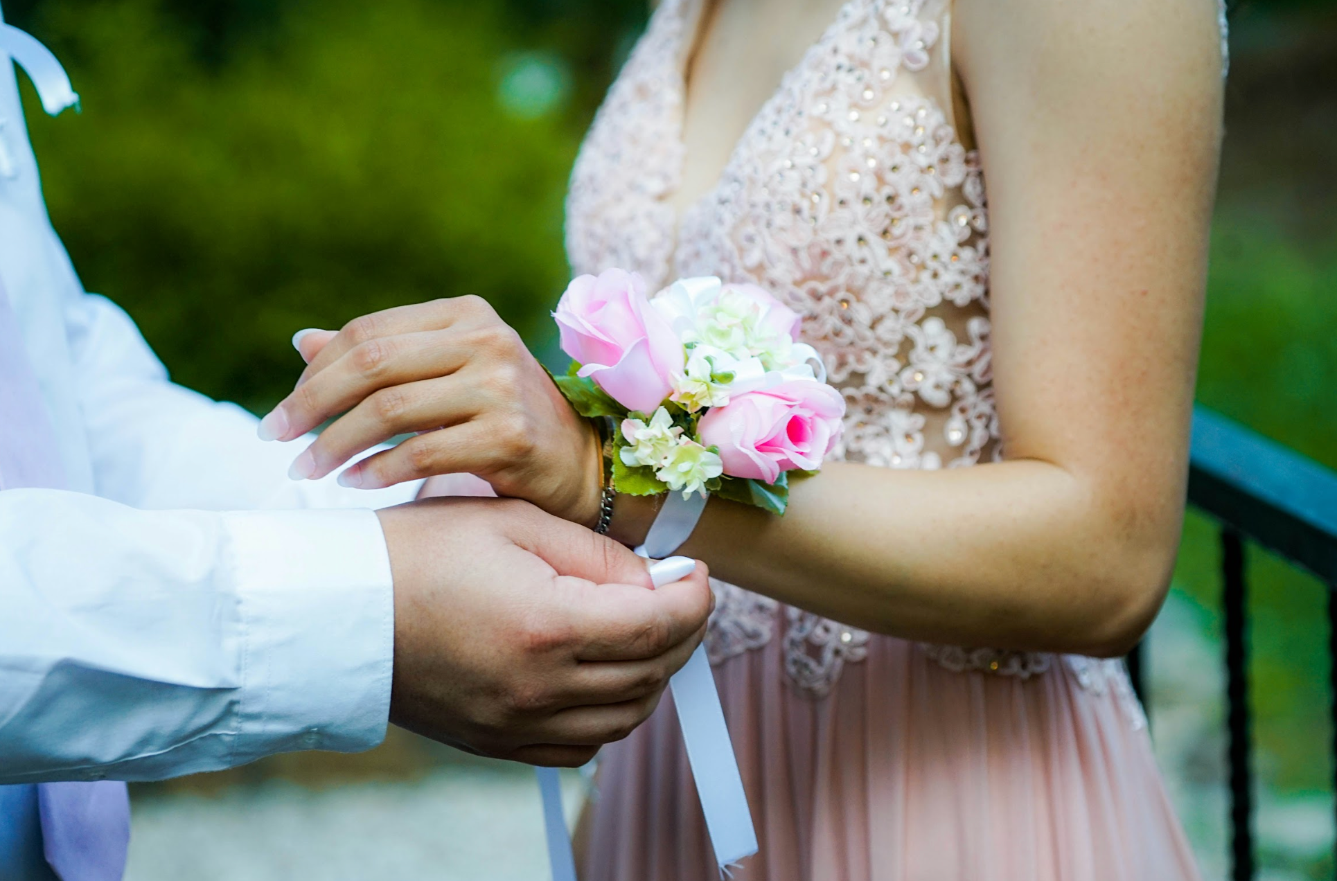 A boy putting a corsage on a girls wrist