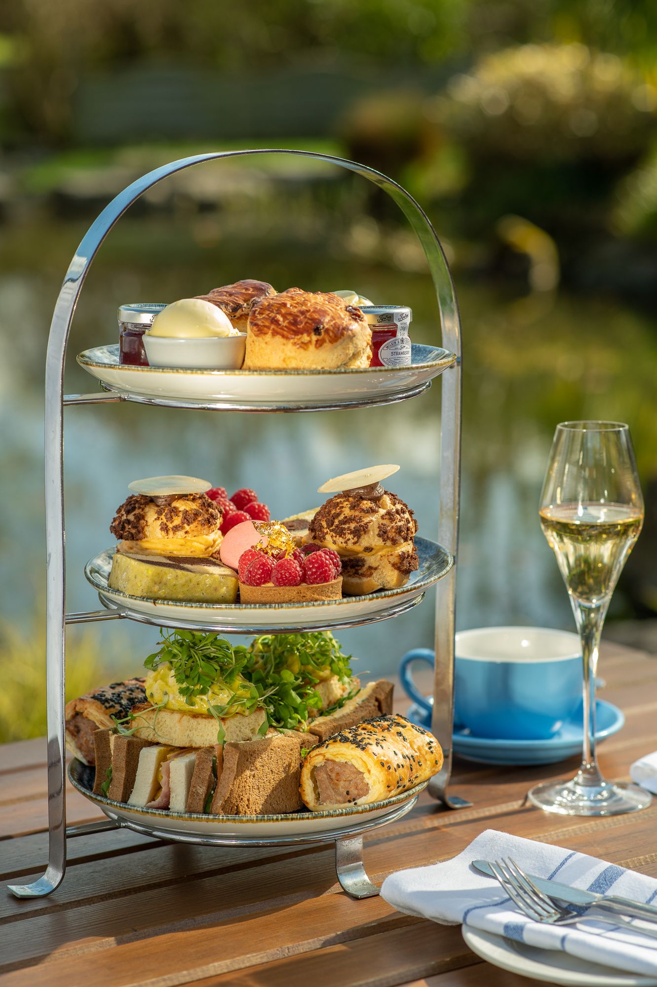 Outdoors afternoon tea with prosecco by a pond