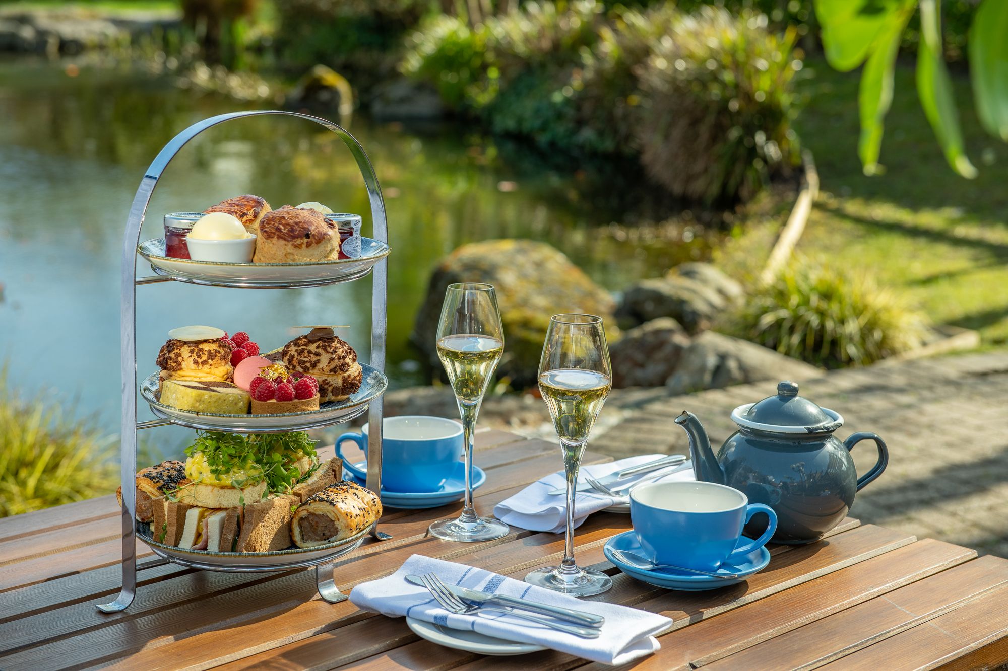 Afternoon tea outdoors with prosecco by a pond