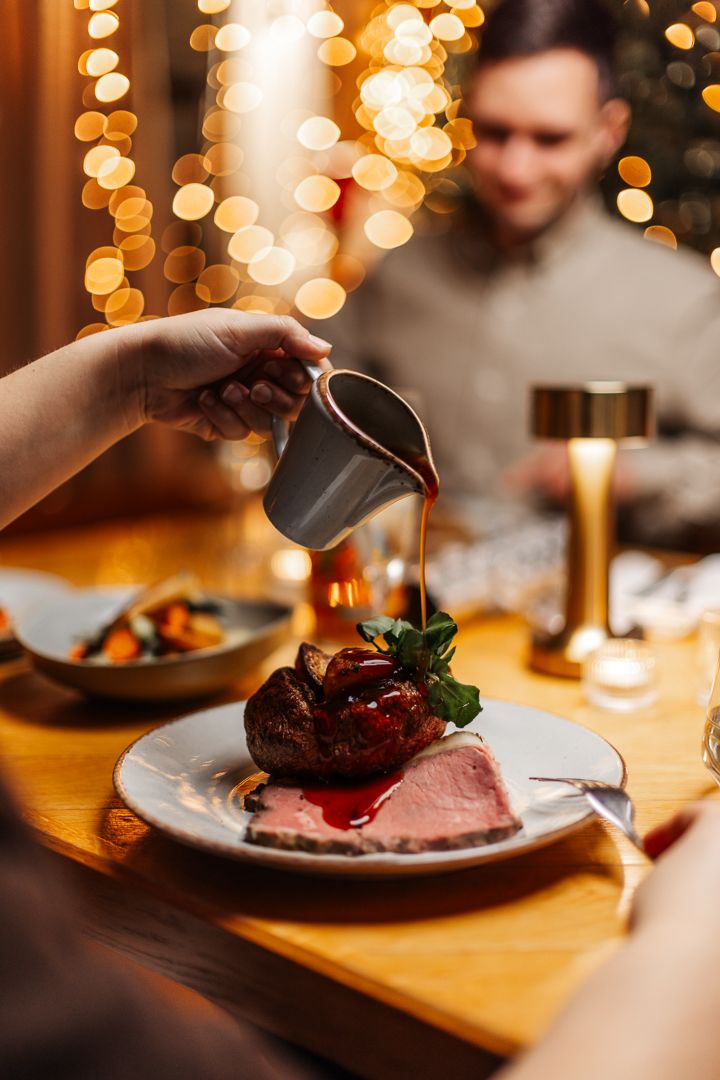 Pouring gravy over beef Christmas dinner