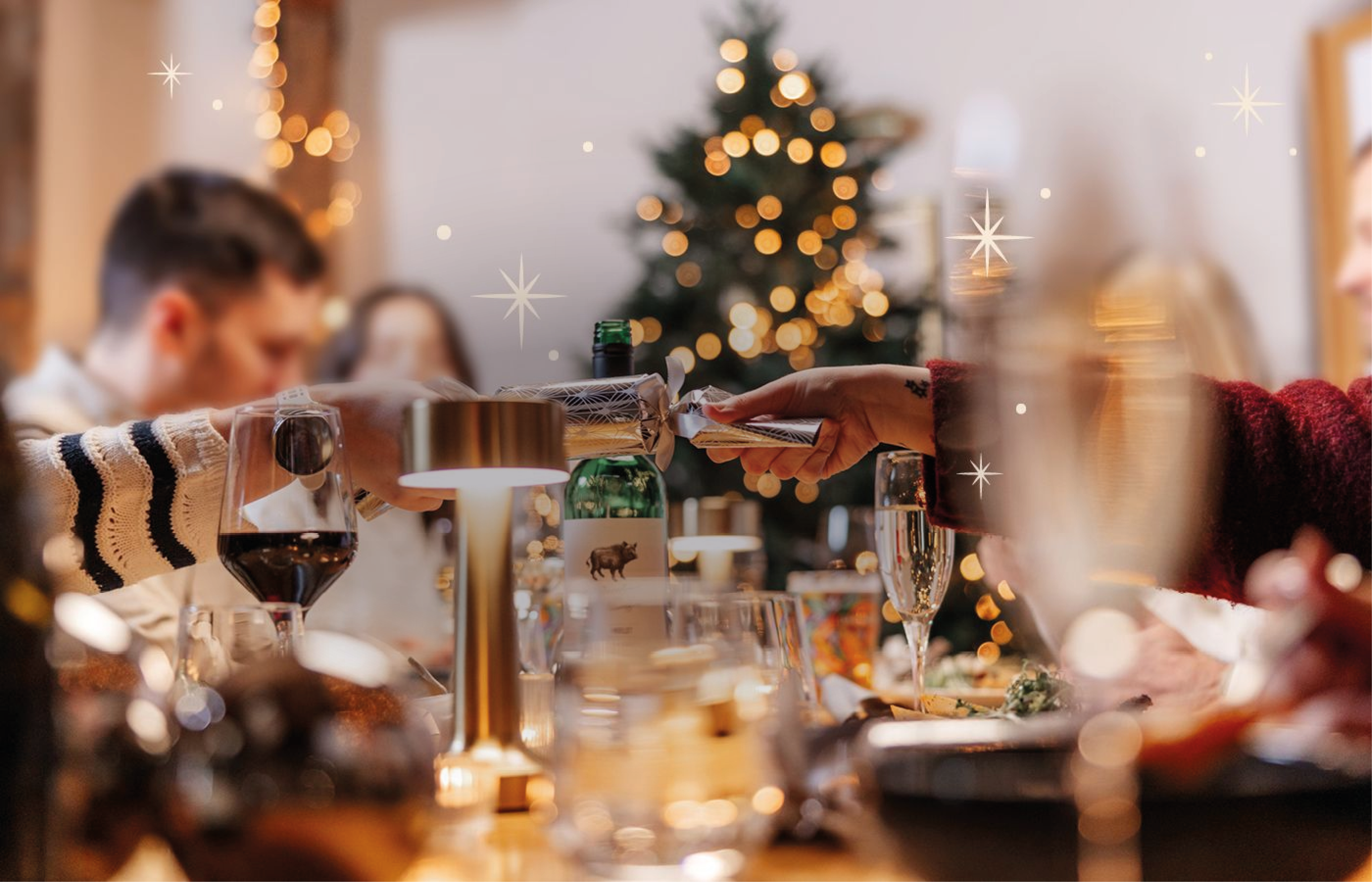 Christmas cracker being pulled amongst festive dining table